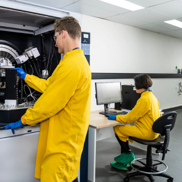 Two scientists in lab in yellow coats