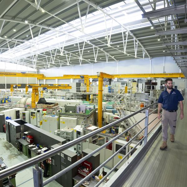 Image of two people walking across an gantry with neutron scattering instruments behind them