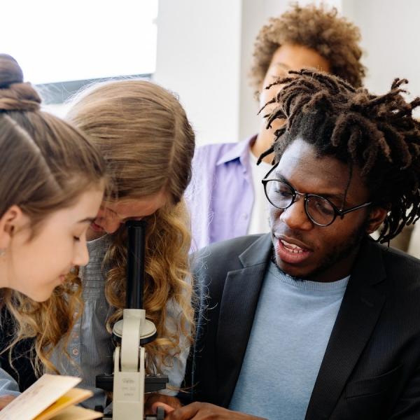 high school students with a microscope