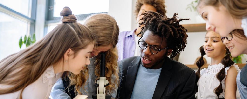 high school students with a microscope