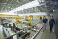 Image of two people walking across an gantry with neutron scattering instruments behind them
