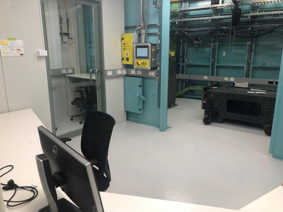 A photo of the MEX1 user cabin looking over the white computer desks towards the MEX1 hutch and sample preparation room.