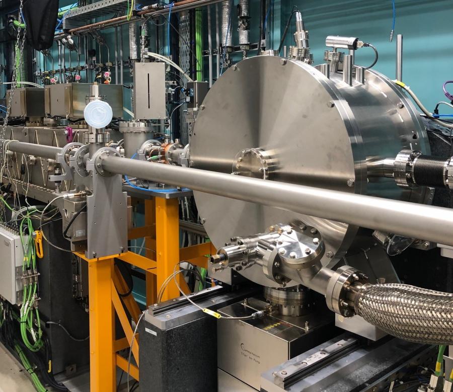 A photo of MEX hutch A, showing silver beamline equipment, with the main focus on a large silver cylinder which is the MEX1 DCM