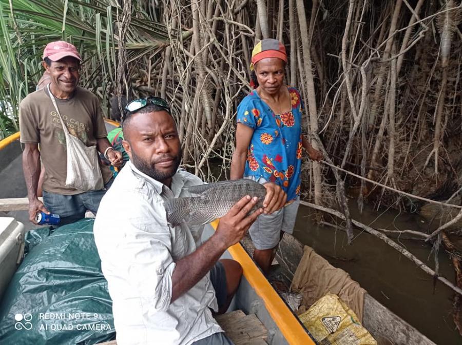 Joshua Noiney, FutureNow scholar in PNG holding Tilapia fish for his research project