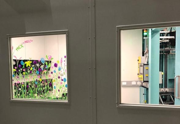 Flowers in bright colours have been drawn on the window looking into the MEX1 user cabin